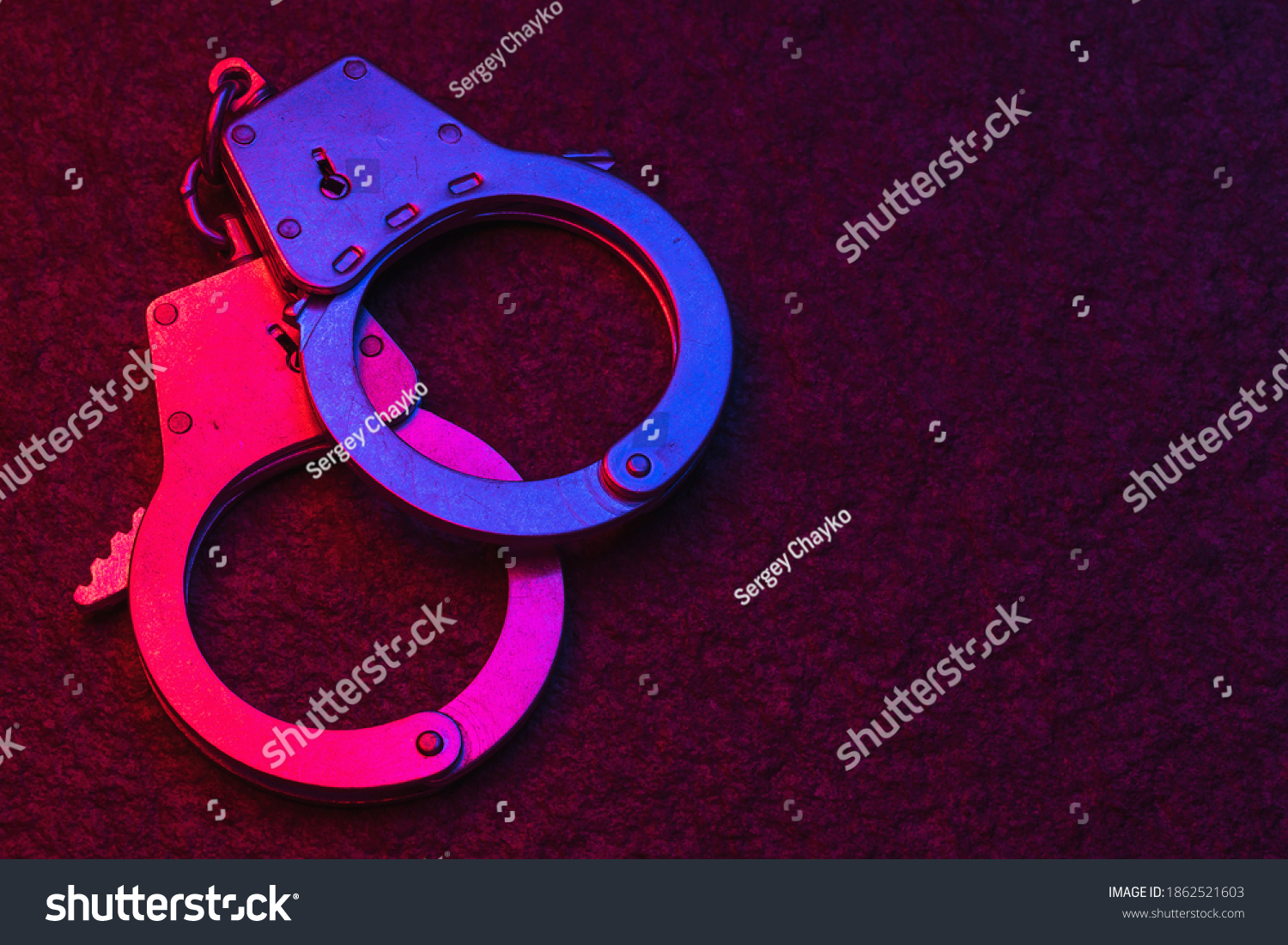 Handcuffs On Dark Background Illuminated By Stock Photo 1862521603 ...