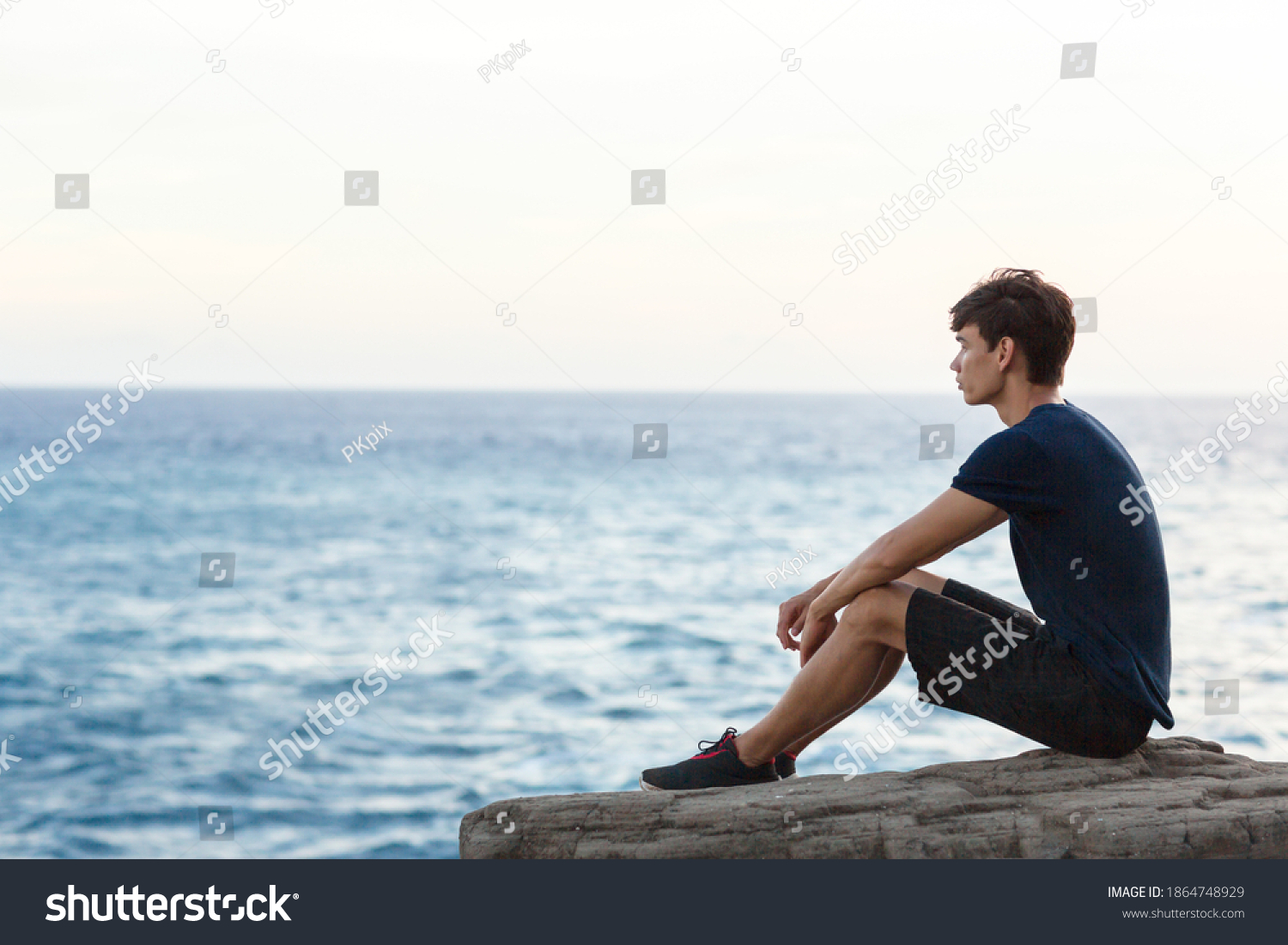 Young Man Sitting Alone On Cliff Stock Photo 1864748929 | Shutterstock