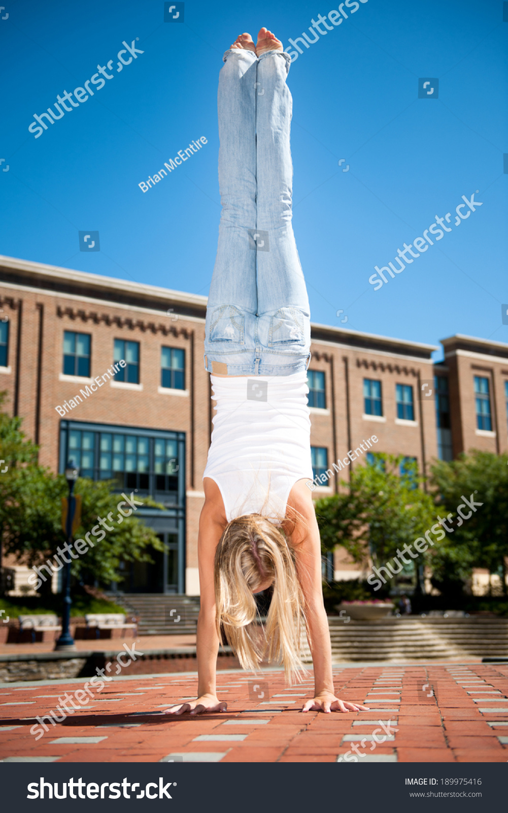https://image.shutterstock.com/shutterstock/photos/189975416/display_1500/stock-photo-athletic-young-woman-doing-a-hand-stand-in-urban-setting-189975416.jpg