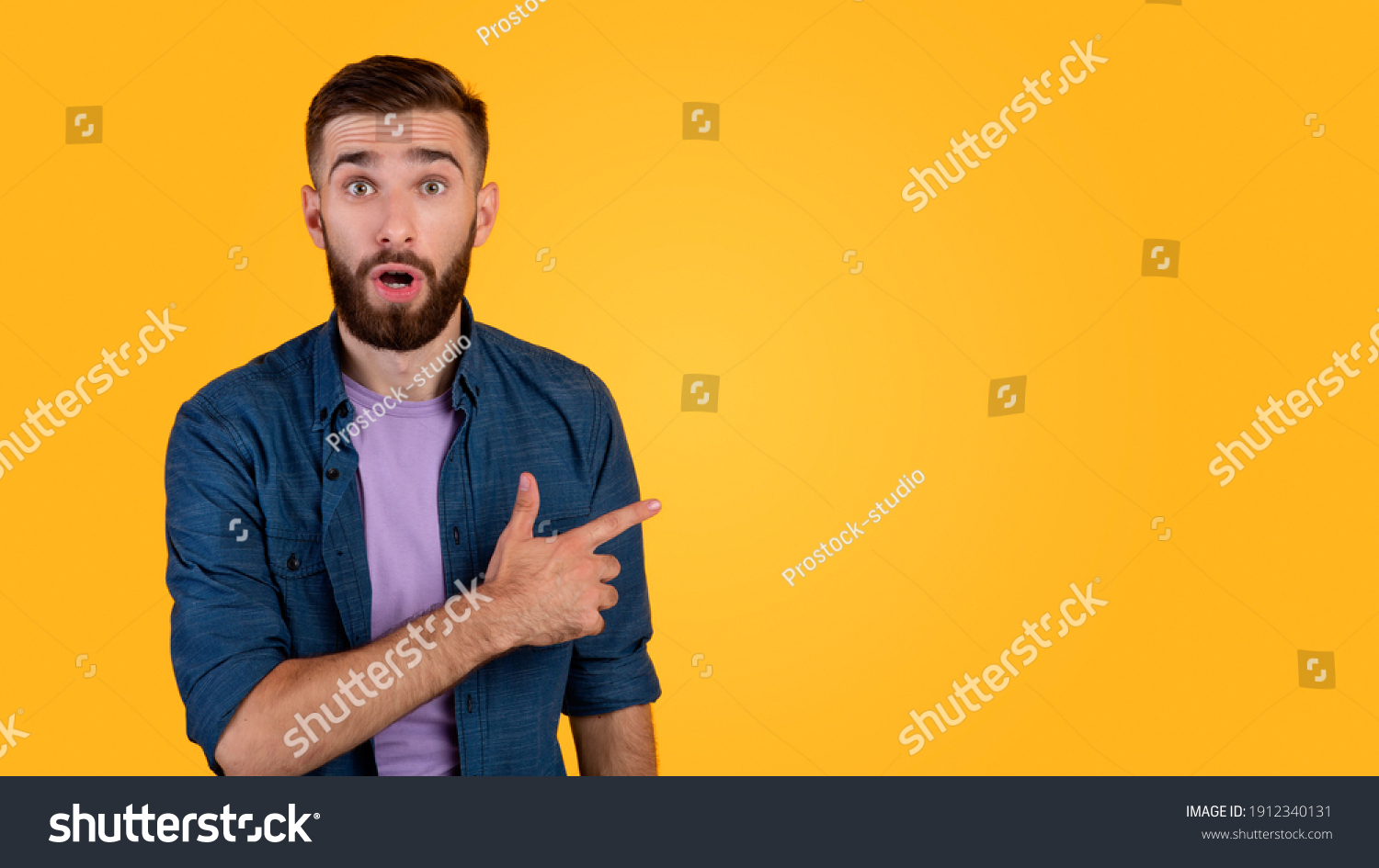 Shocked Millennial Guy Pointing Aside Empty Stock Photo 1912340131 ...