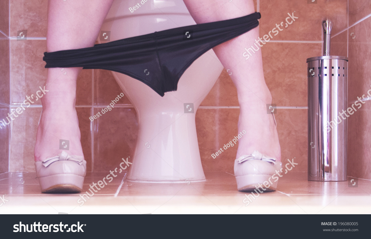 Woman Sitting Peeing On Toilet Stock