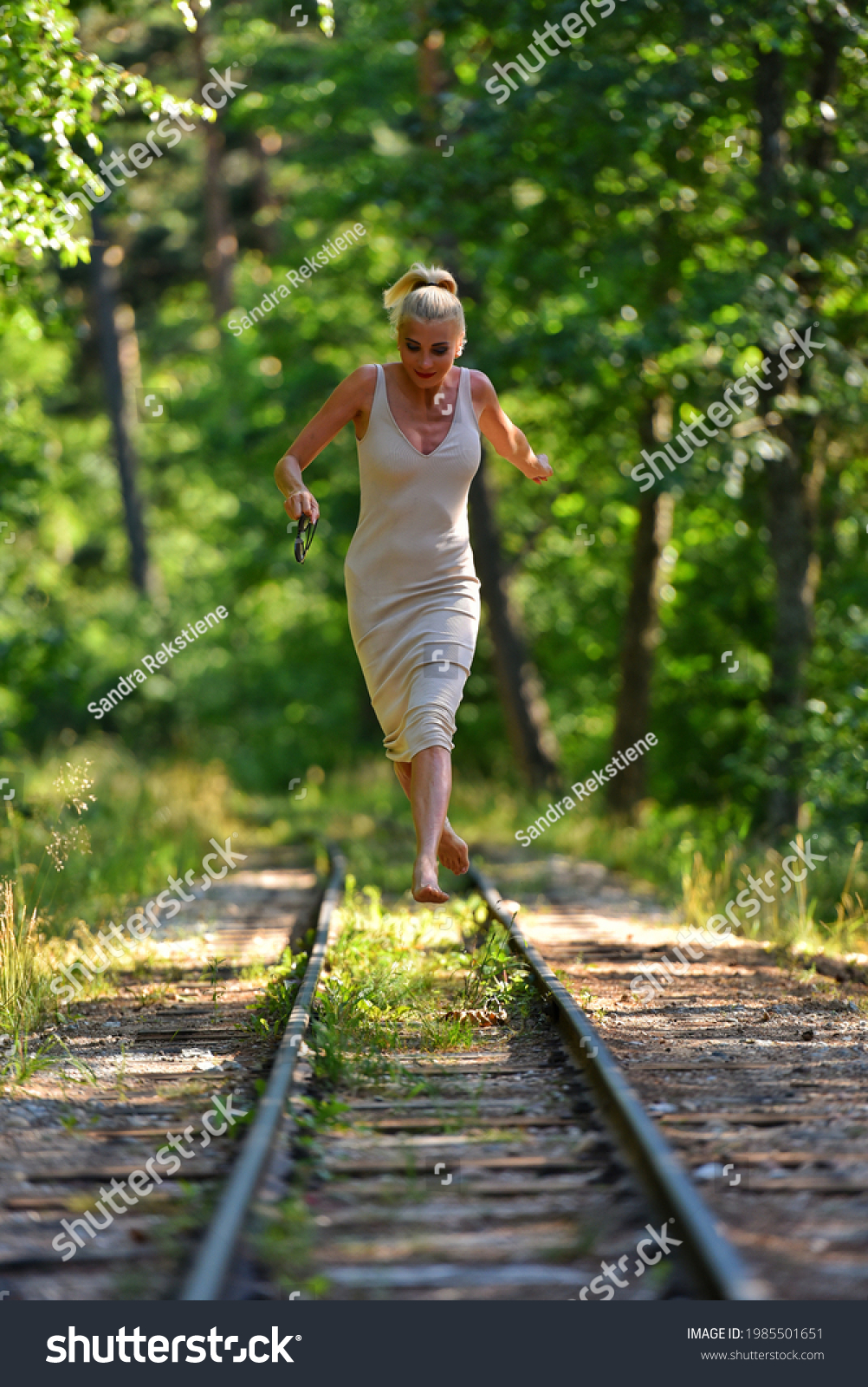 https://image.shutterstock.com/shutterstock/photos/1985501651/display_1500/stock-photo-caucasian-blonde-barefoot-model-in-nude-dress-walks-along-the-along-railroad-on-a-summer-day-1985501651.jpg