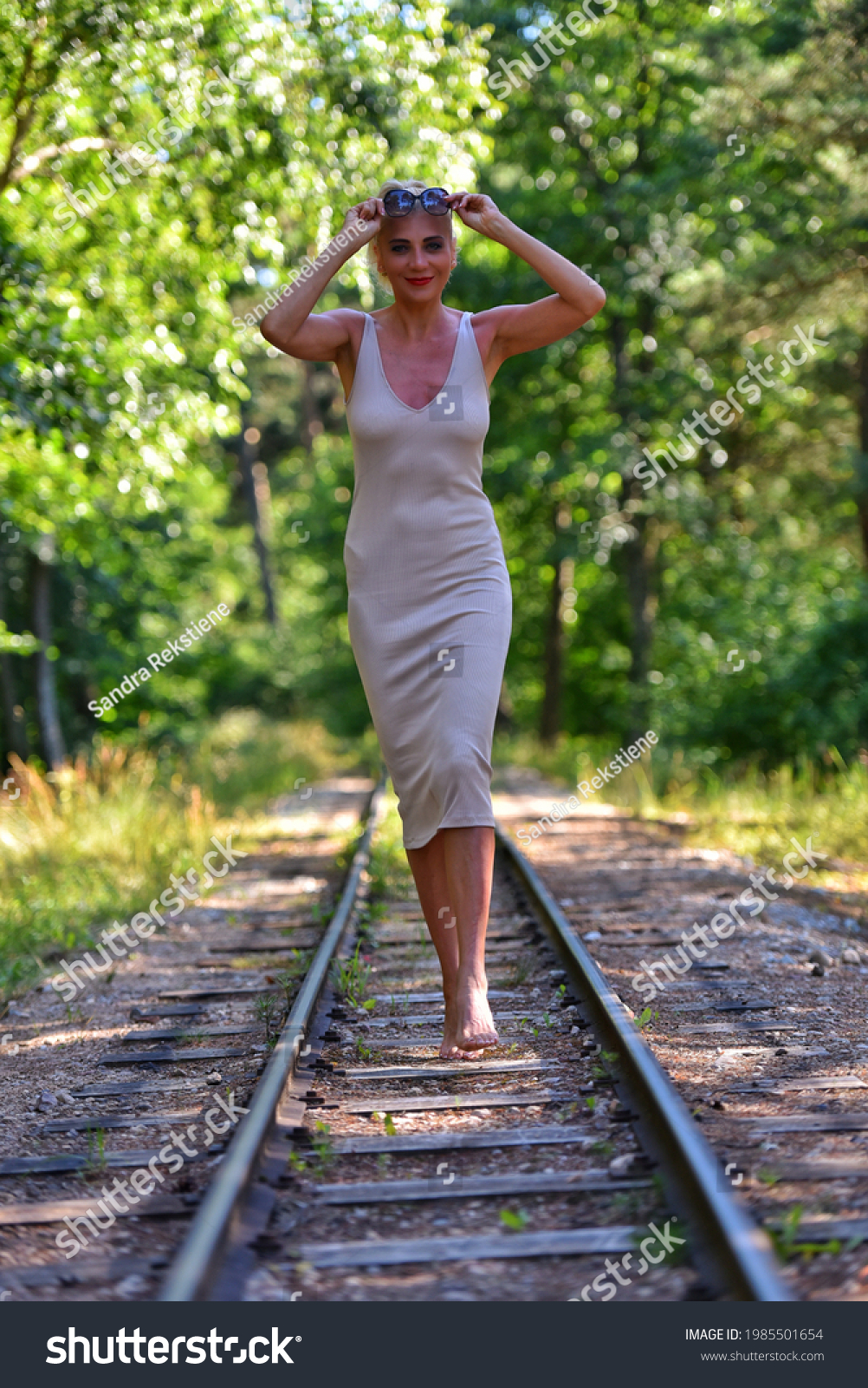 https://image.shutterstock.com/shutterstock/photos/1985501654/display_1500/stock-photo-caucasian-blonde-barefoot-model-in-nude-dress-walks-along-the-along-railroad-on-a-summer-day-1985501654.jpg