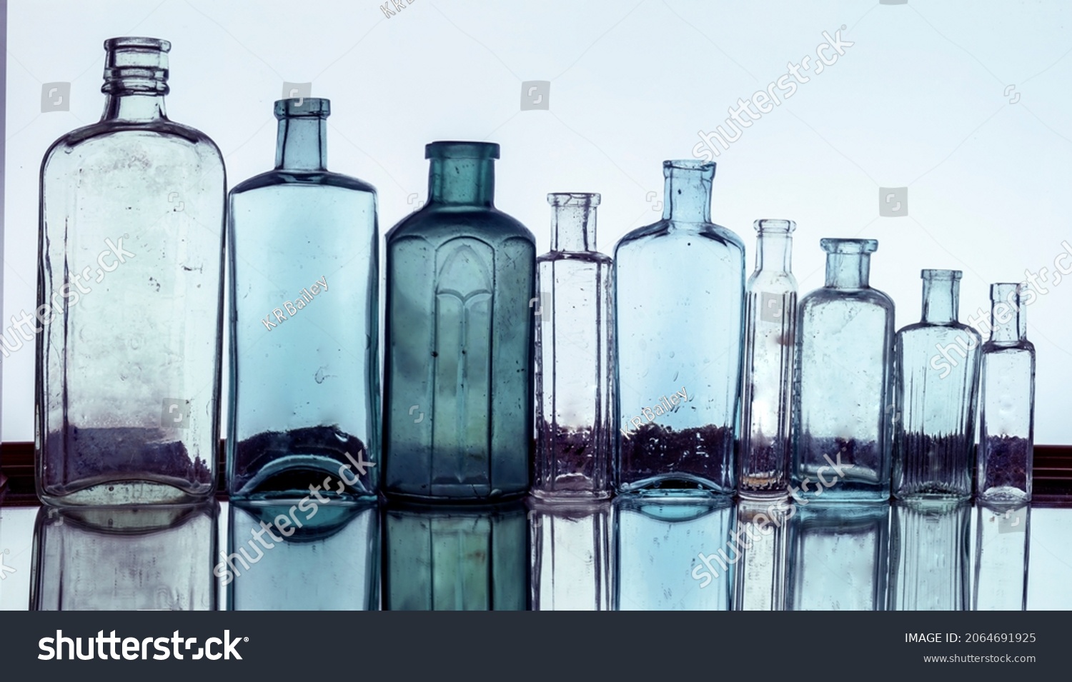 6 881 Blue Antique Bottle Images Stock Photos Vectors Shutterstock   Stock Photo A Line Of Blank Antique Bottles Shot With A Blue Colour Tone 2064691925 