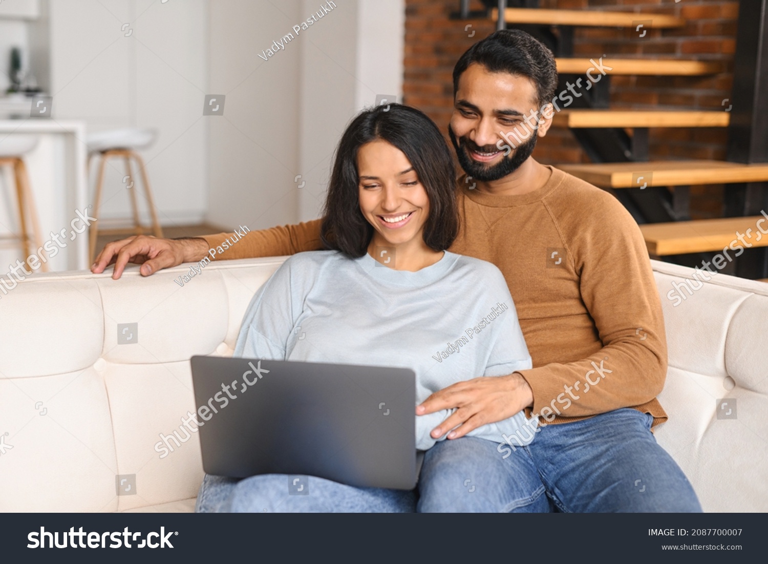 Serene Indian Couple Spending Time Together At Home, Using Laptop Stock