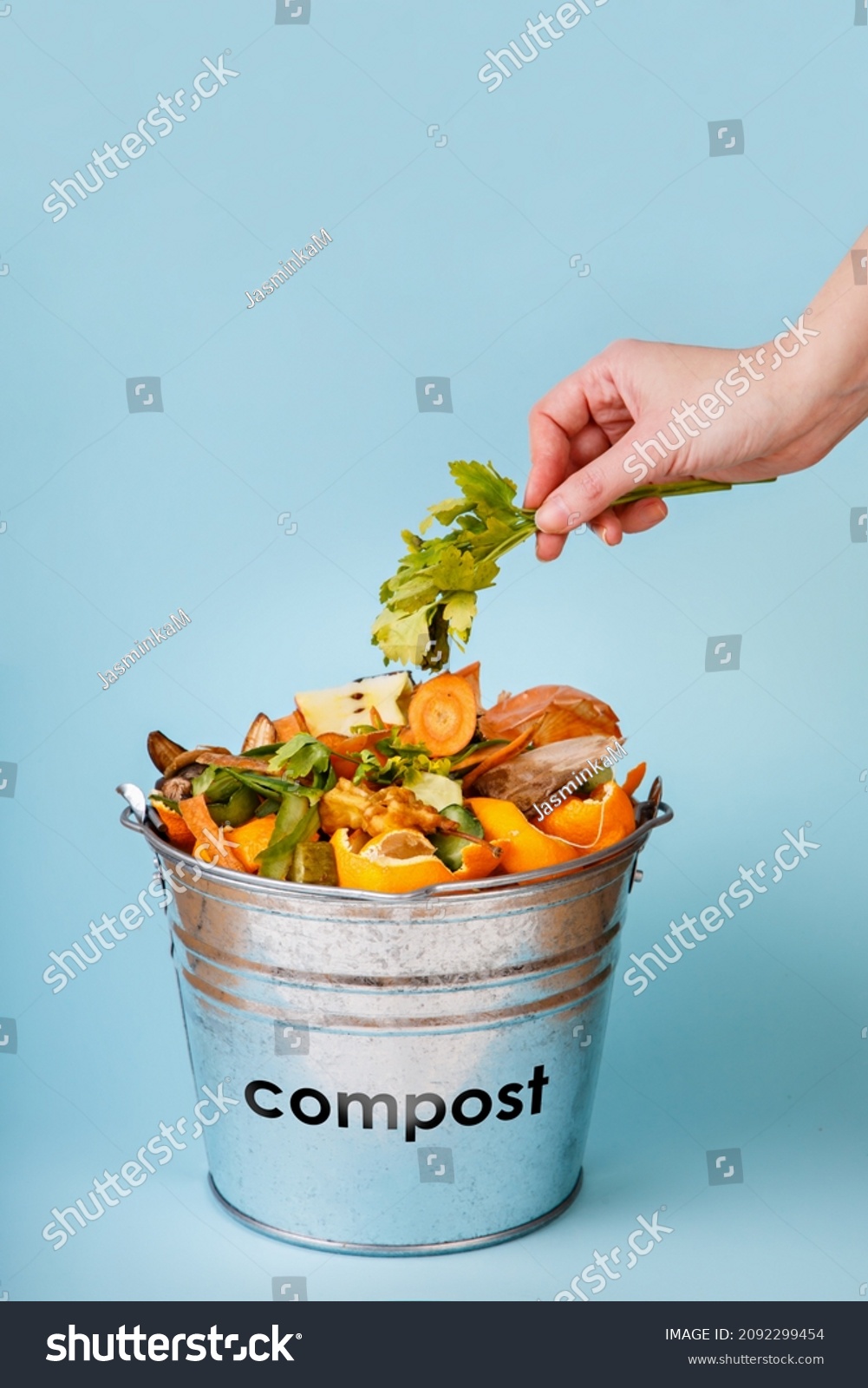 Woman Puts Kitchen Waste Compostbucket On Stock Photo 2092299454   Stock Photo Woman Puts Kitchen Waste In Compost Bucket On Blue Background Compost Container Sustainable 2092299454 