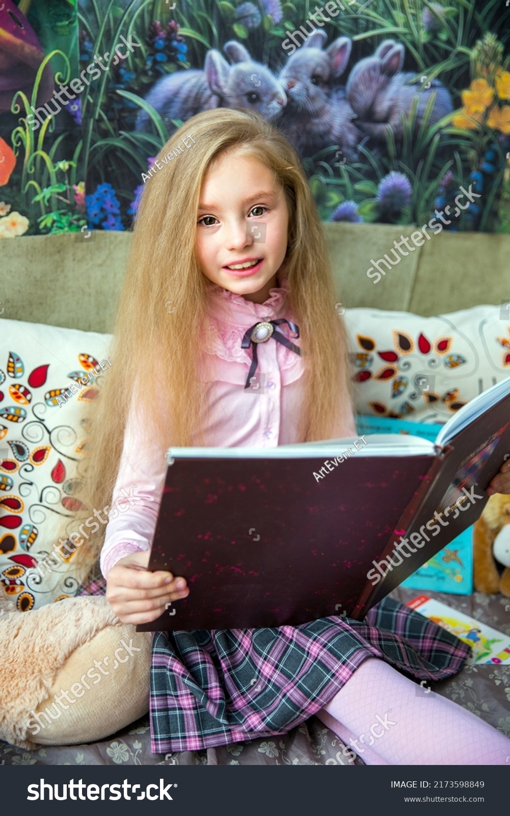 cute-little-girl-reading-interesting-book-stock-photo-2173598849