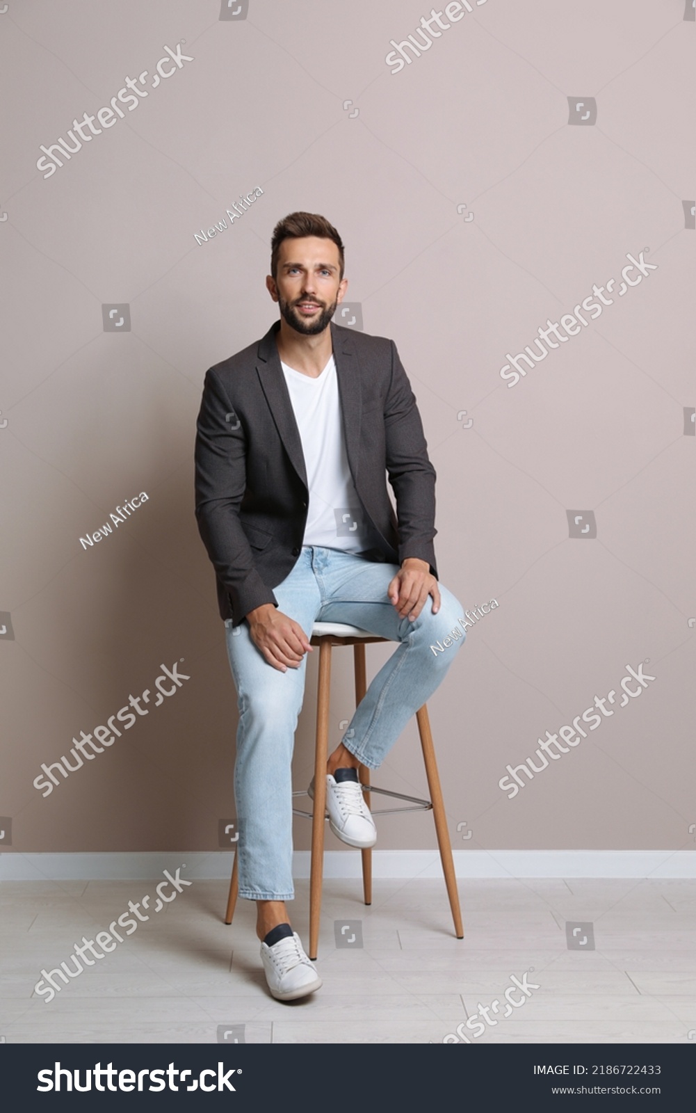 Handsome Man Sitting On Stool Near Stock Photo 2186722433 Shutterstock   Stock Photo Handsome Man Sitting On Stool Near Beige Wall 2186722433 