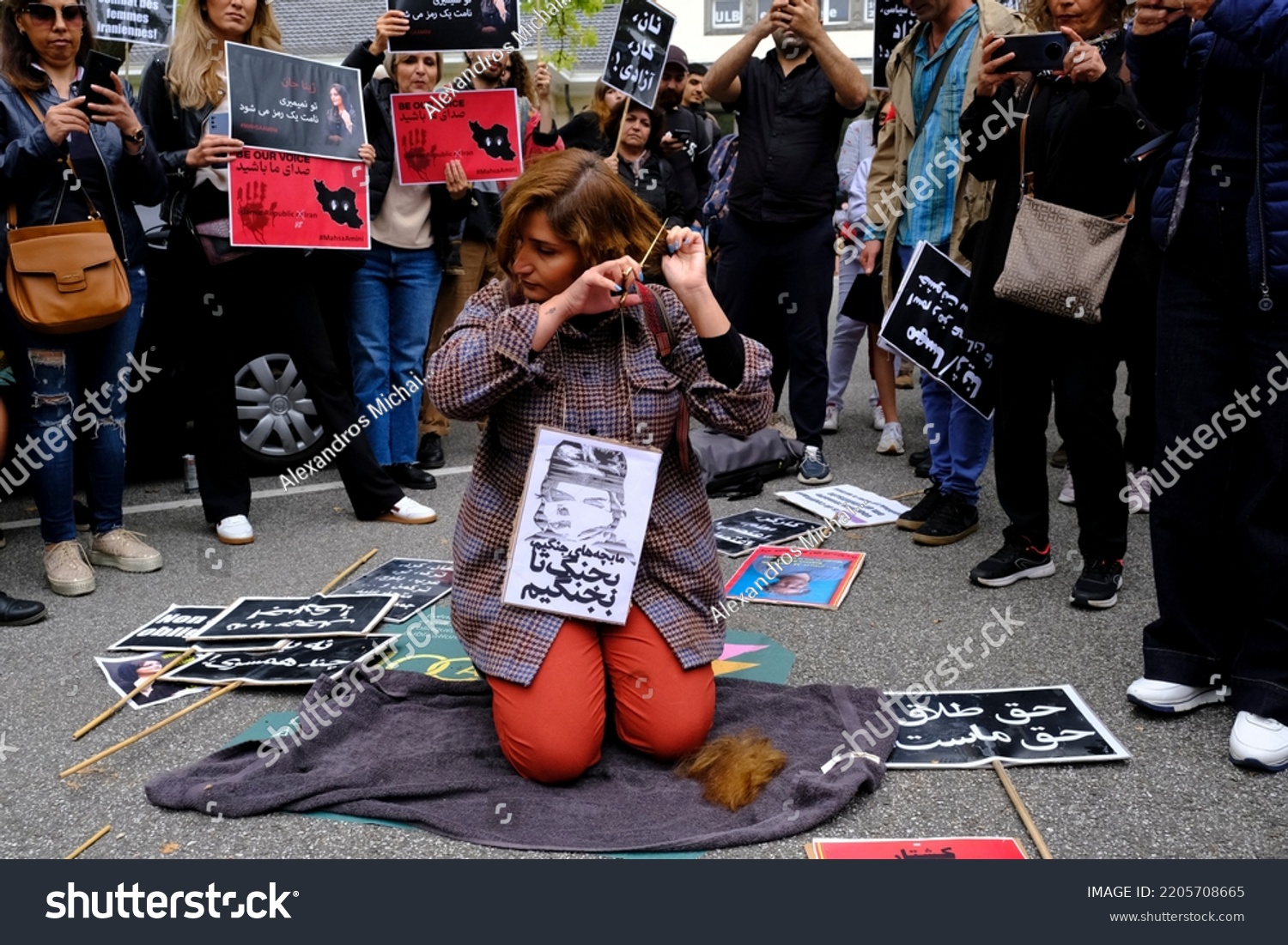 woman-cuts-her-hair-during-demonstration-stock-photo-2205708671