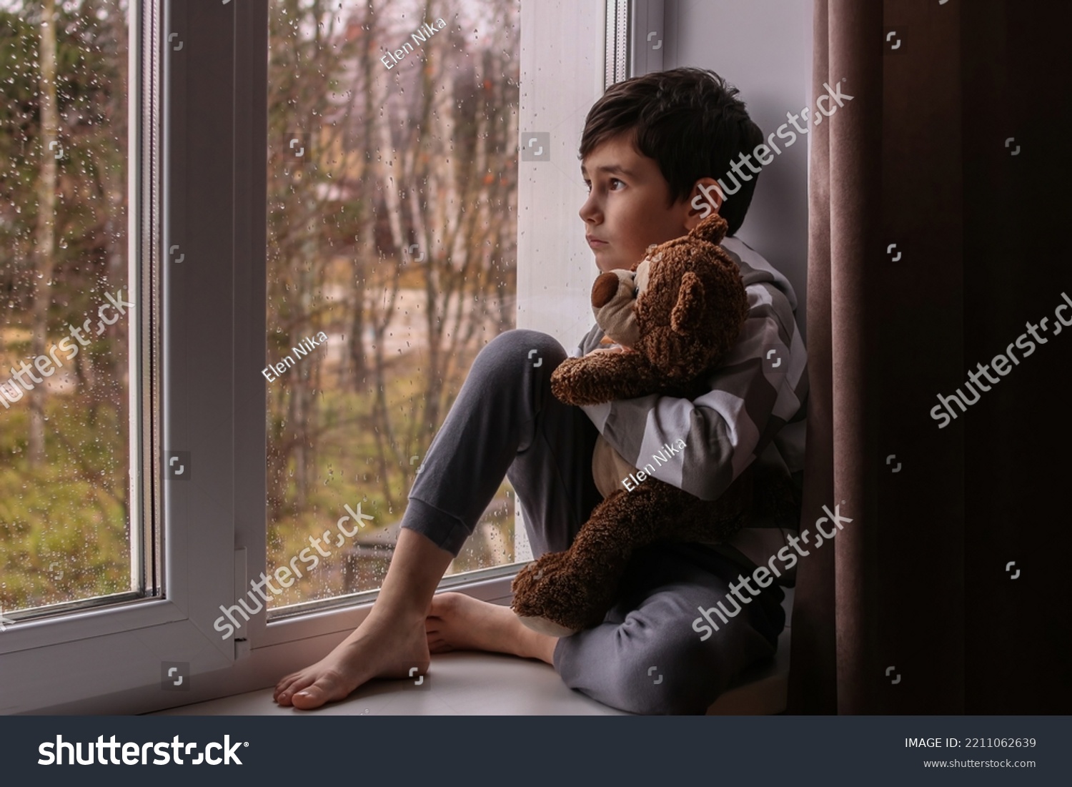 Sad Boy Looks Out Window Hugging Stock Photo 2211062639 Shutterstock Sad Boy Looks Out Window Hugging Stock Photo 2211062639 Shutterstock