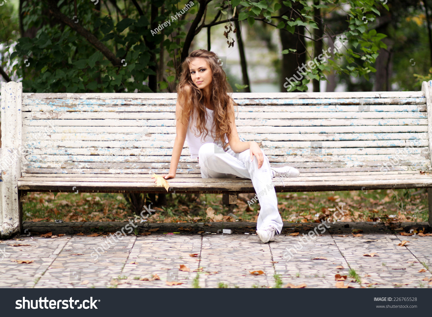 Молодая девушка на скамейке в парке