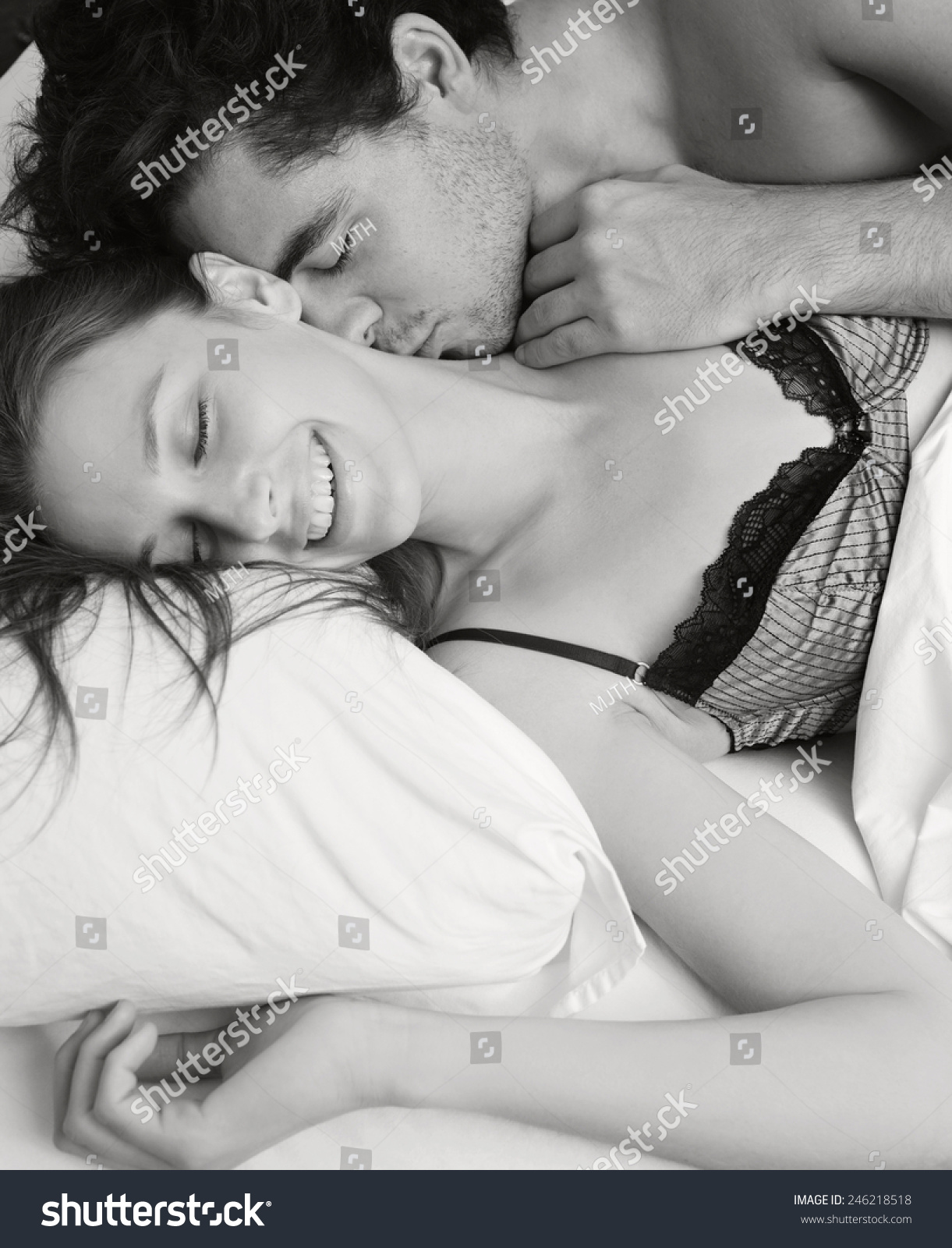 Мужчина лежит на женщине и целует