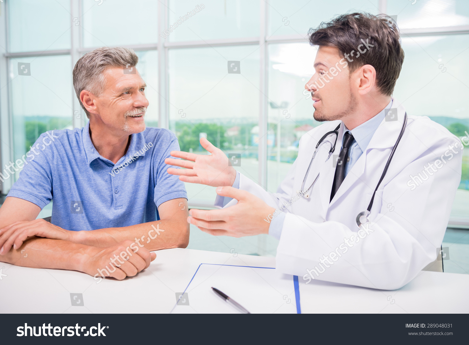 male-doctor-talking-patient-seriously-clinic-stock-photo-289048031