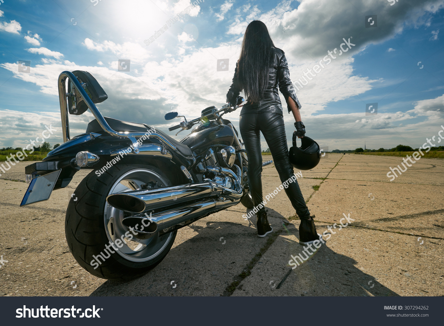 Брюнетка на мотоцикле со спины
