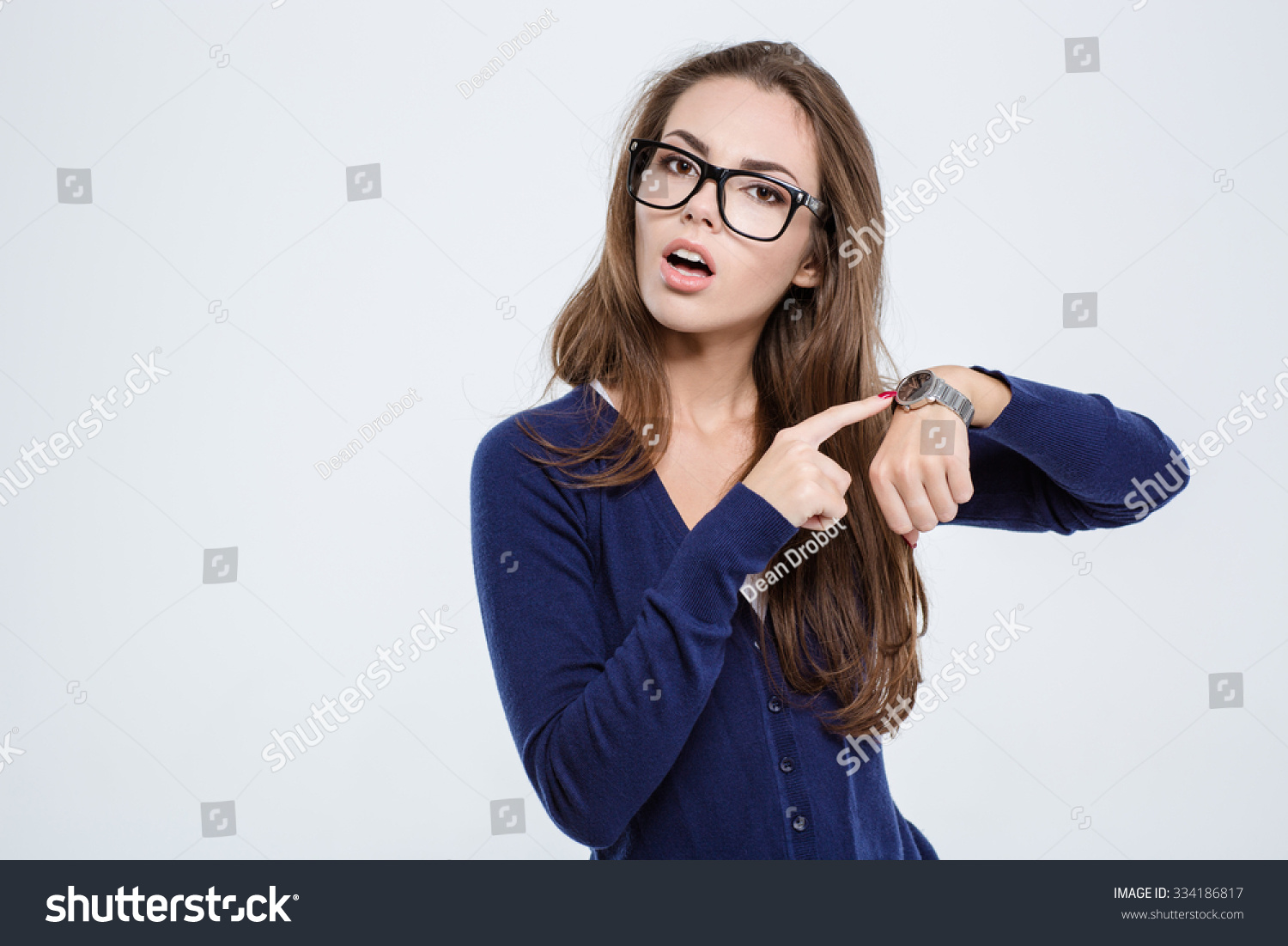 Женщина смотрит на часы. Девушка указывает. Девушка указывает на часы. Девушка показывает на часы. Удивленная девушка с часами.