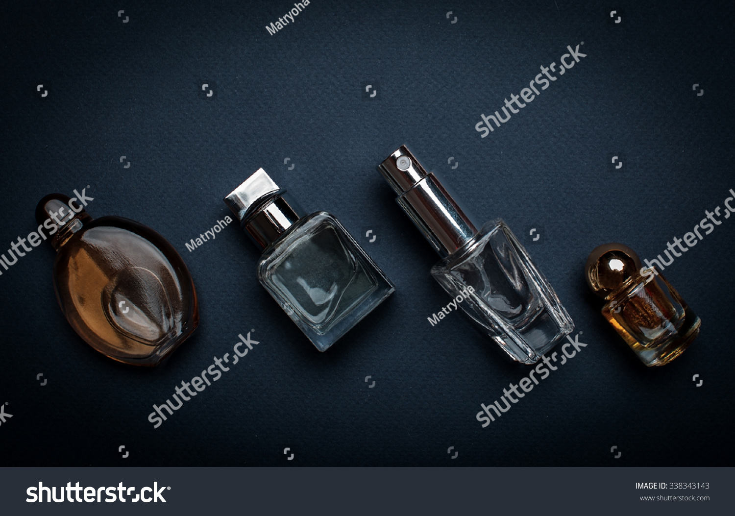 Different Perfume Bottles On Dark Background Stock Photo 338343143