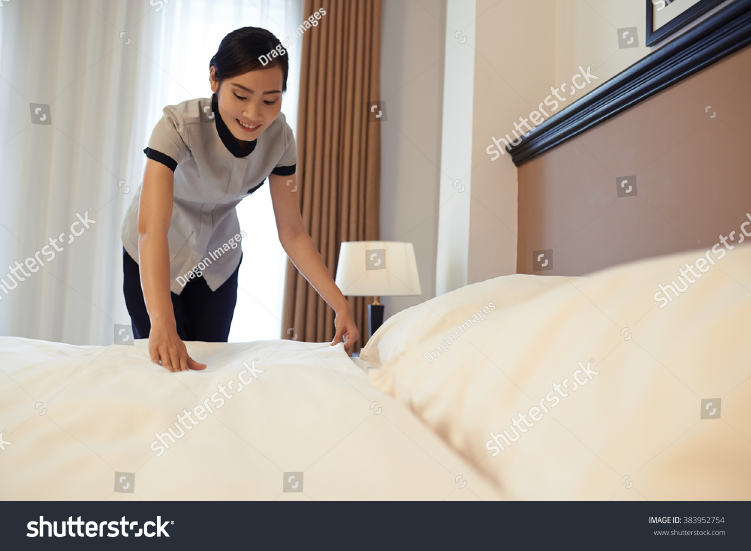 Горничная заправляет кровать