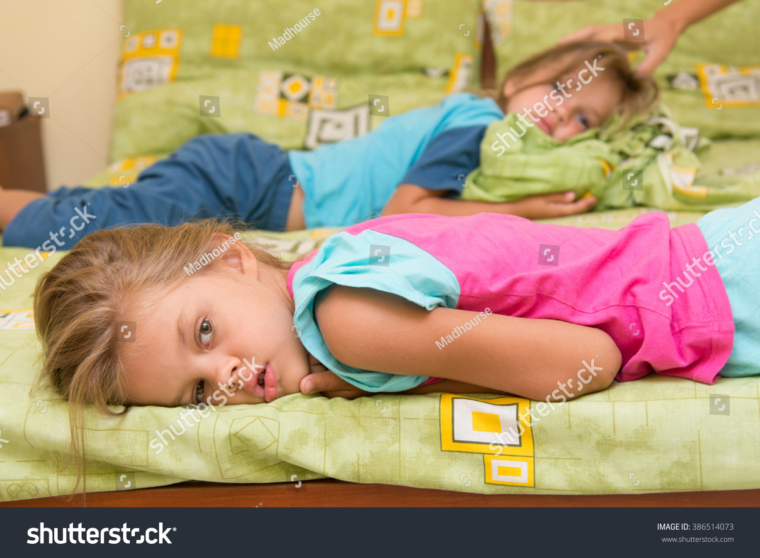 Две девочки лежат на кровати