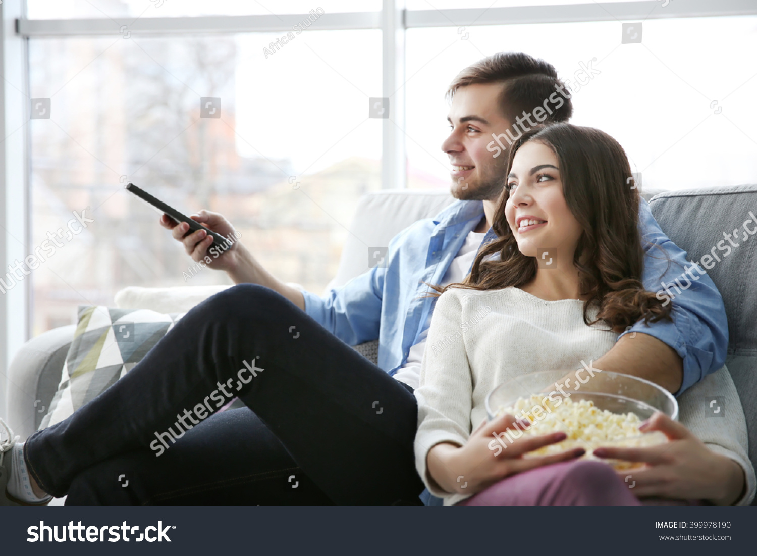 Молодая пара смотрит телевизор