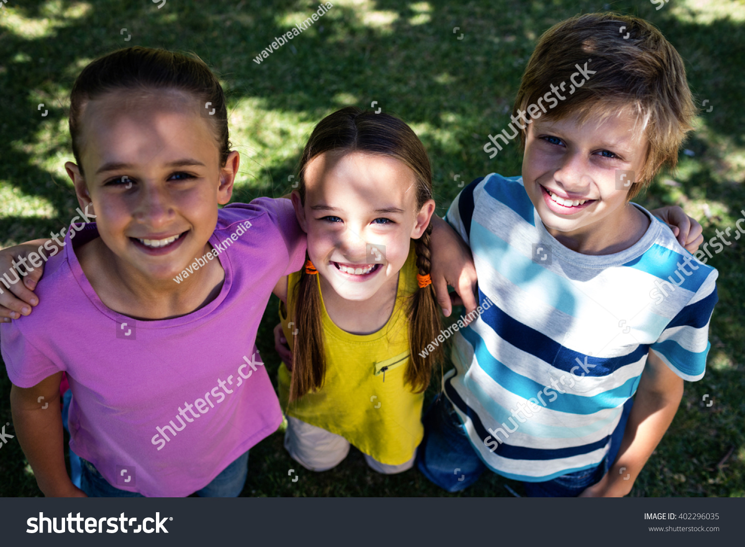 Stock Photo Portrait Of Happy Children Standing With Arm Around In Park 402296035 