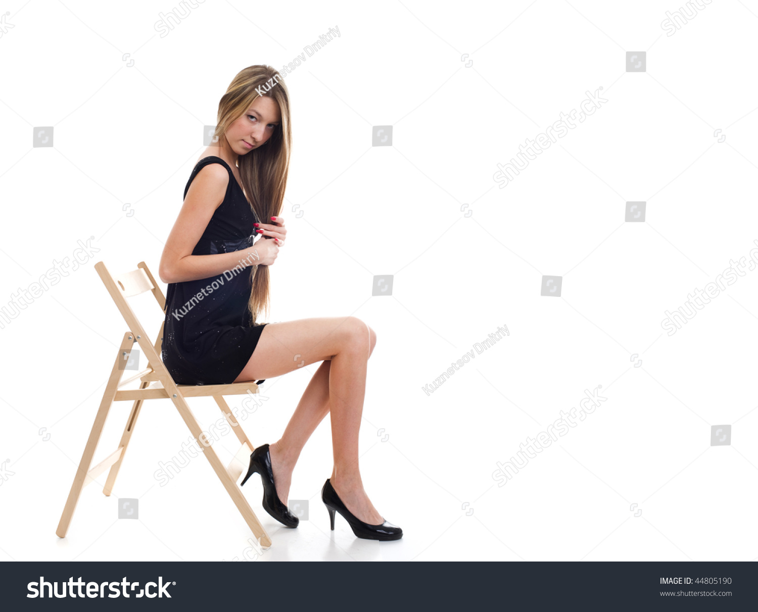 Vollbusige Blondine masturbiert auf einem Stuhl