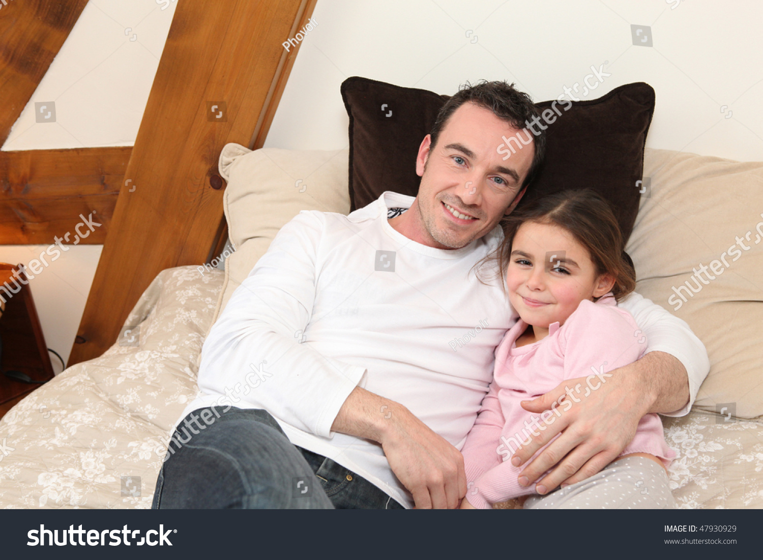 Папа обнимает дочку на кровате
