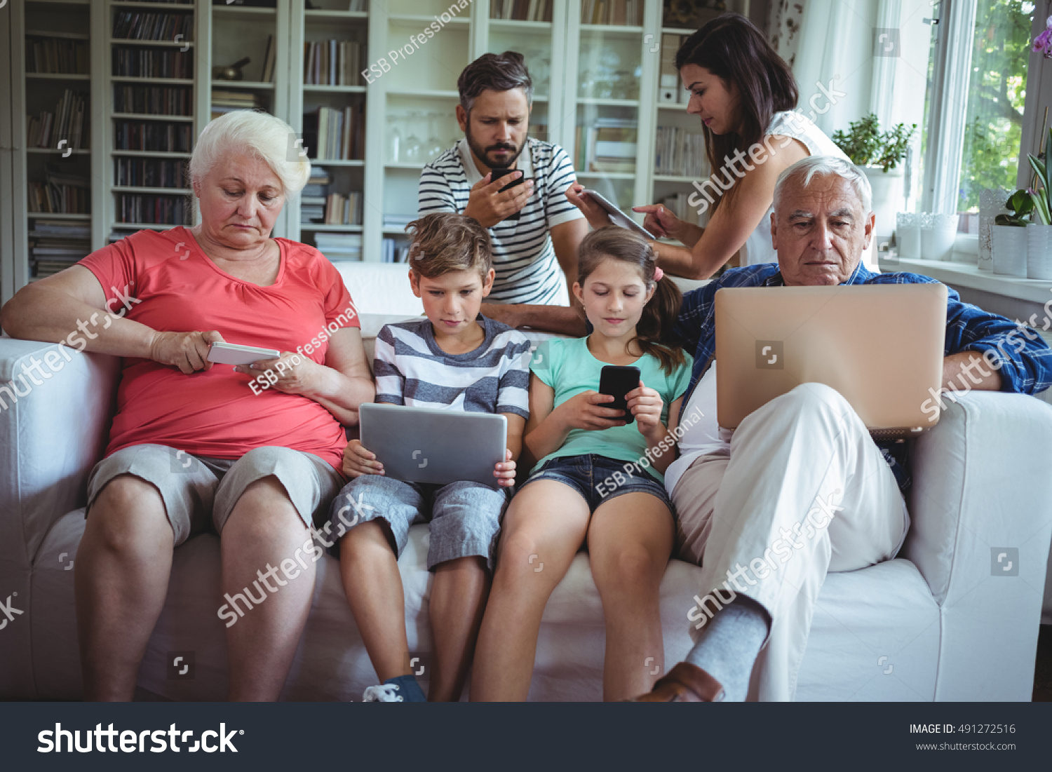 Multigeneration Family Sitting On Sofa Using Stock Photo 491272516   Stock Photo Multi Generation Family Sitting On Sofa And Using Laptop Mobile Phone And Digital Tablet 491272516 