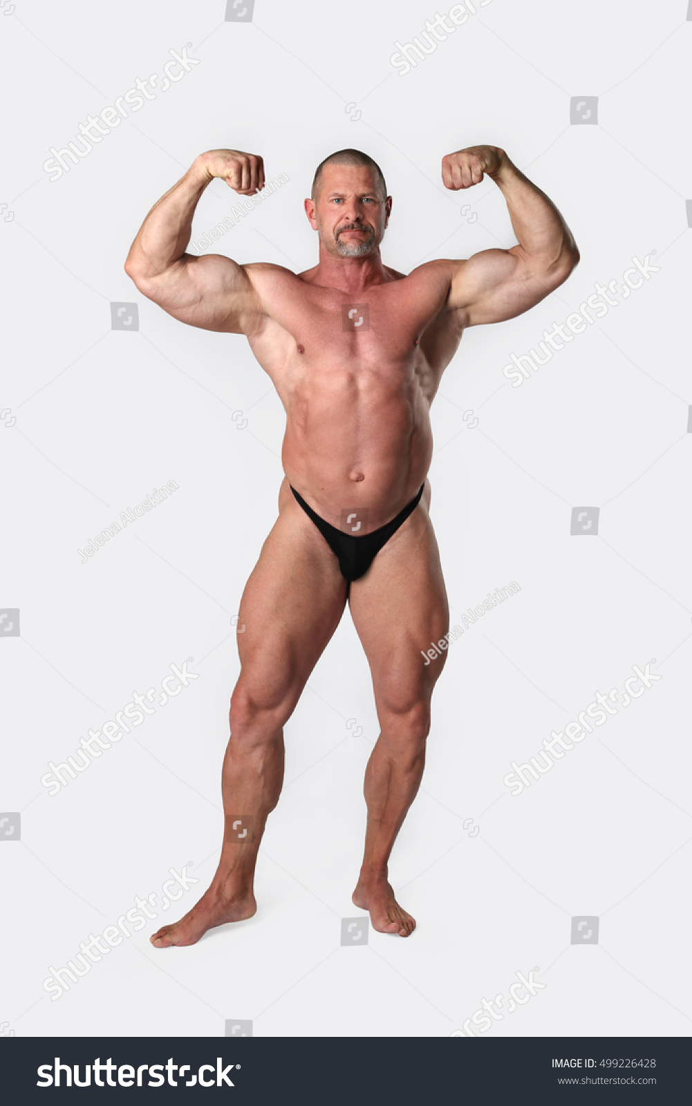 stock-photo-athletic-strong-man-poses-and-showing-strained-muscles-of-his-naked-body-on-gray-background-499226428.jpg