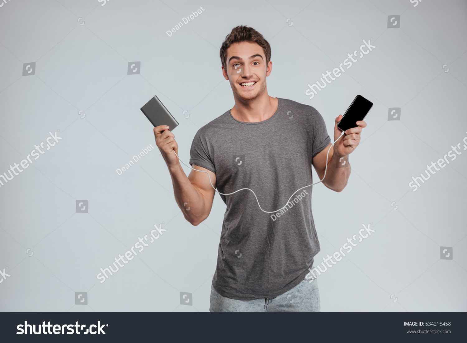 Standing o. Мужчина со смартфоном. Человек с мобильным телефоном. Парень с телефоном в руке. Радостный человек с телефоном.