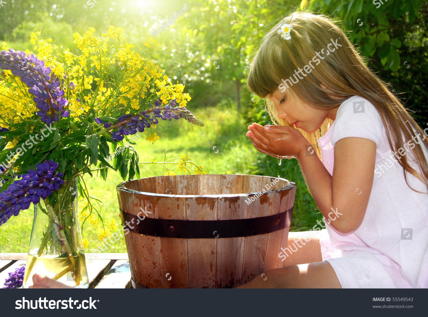 Ребенок пьет воду из колодца
