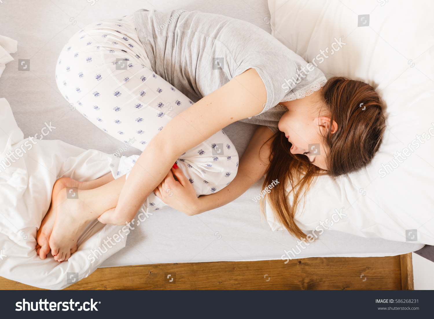 Спать поджав ноги. Девушка свернулась клубком. Лежать клубочком. Поза эмбриона во сне.