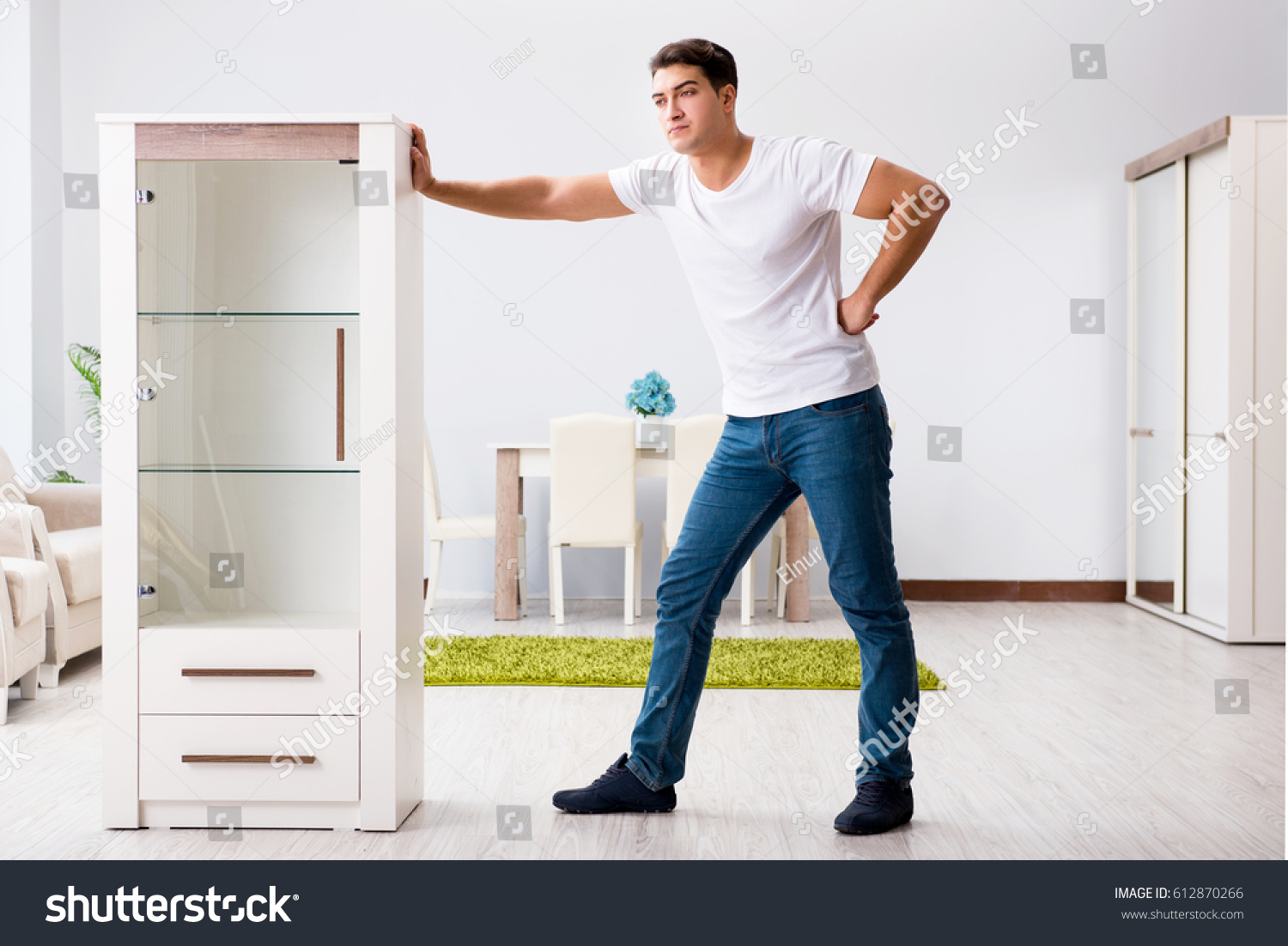Мужчина двигает шкаф