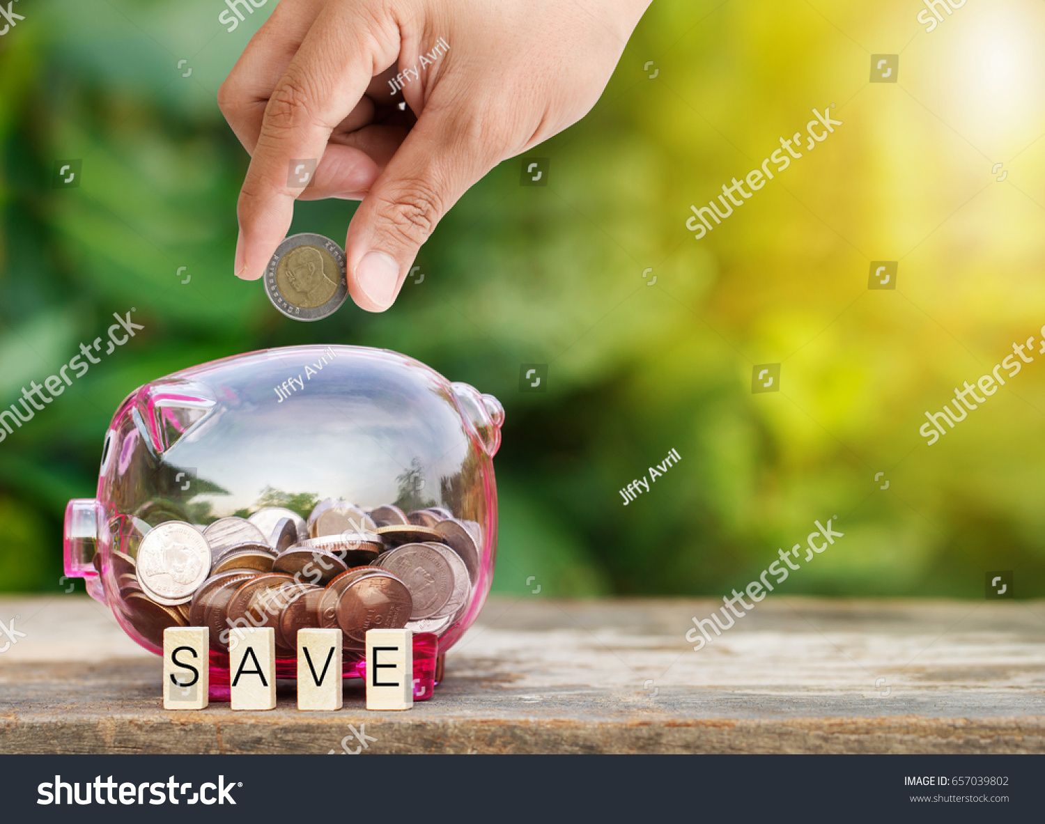 man-hand-putting-coin-into-piggy-stock-photo-657039802-shutterstock