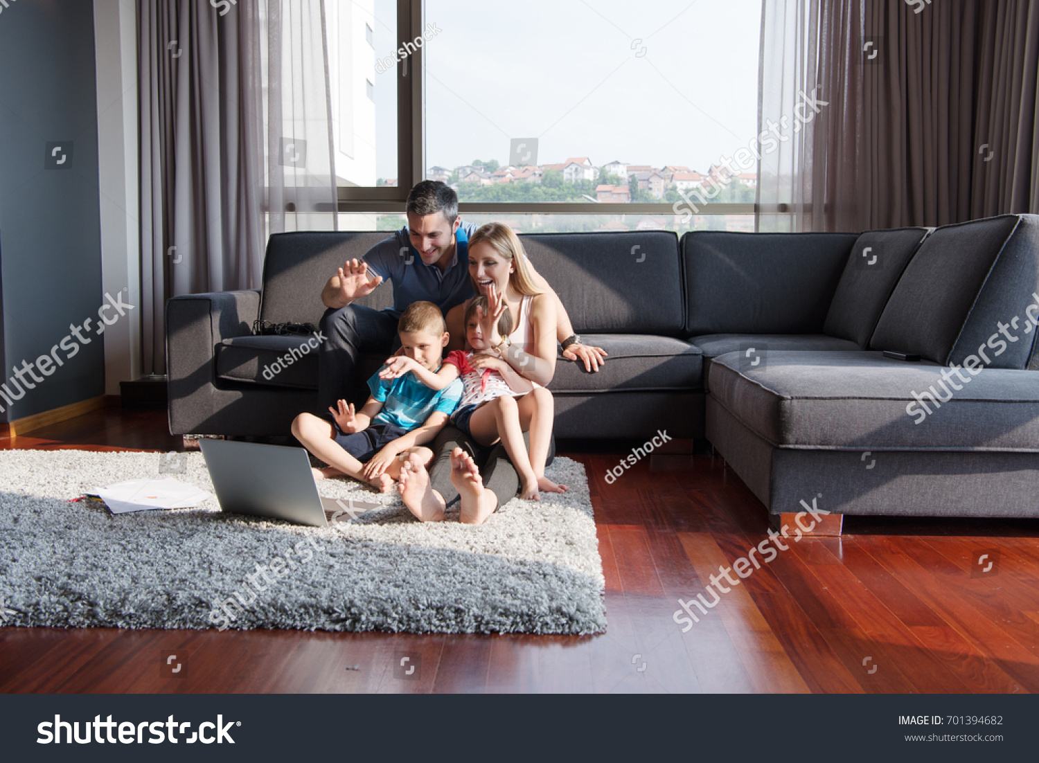 Семья сидит на диване дома