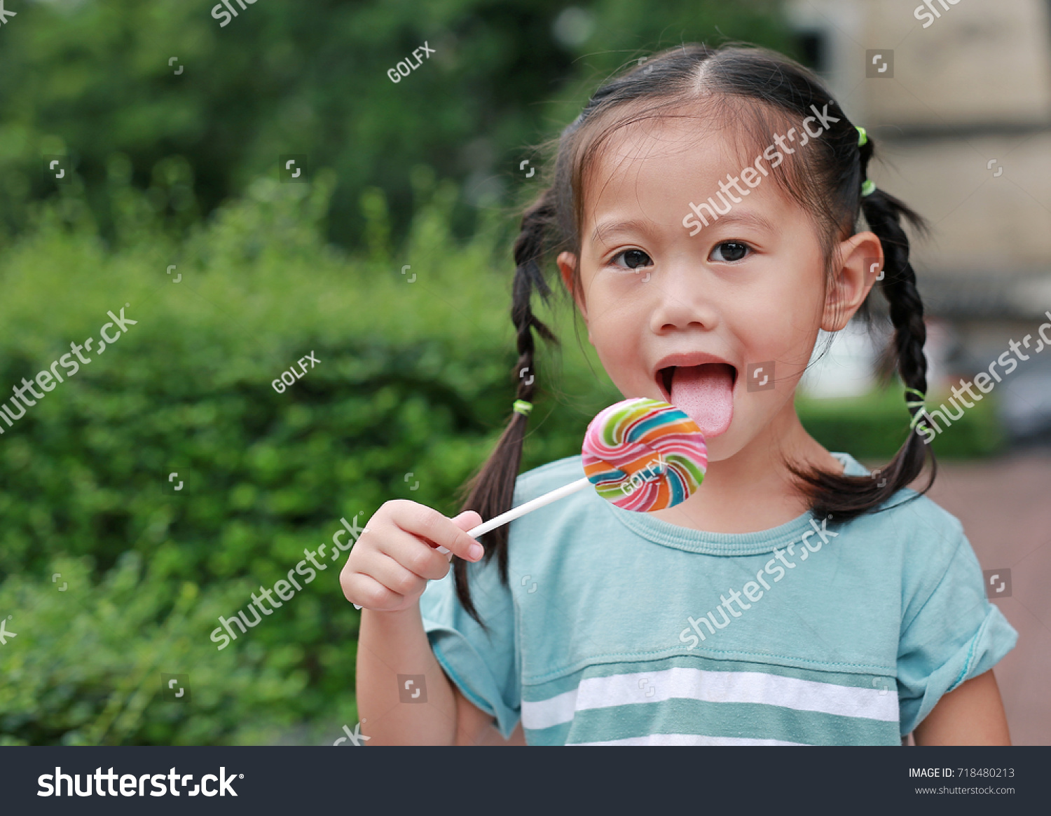 Happy Little Girl Licking Lollipop Candy Stock Photo 718480213 ...