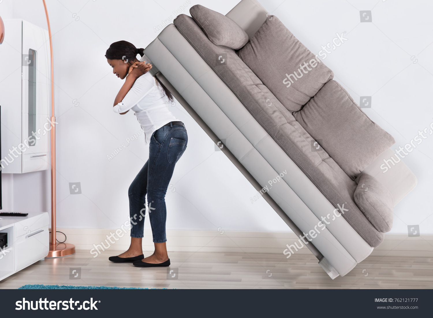 Девушка передвигает диван