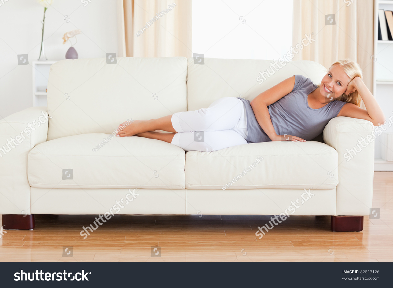 Женщина блондинка отдыхает на диване