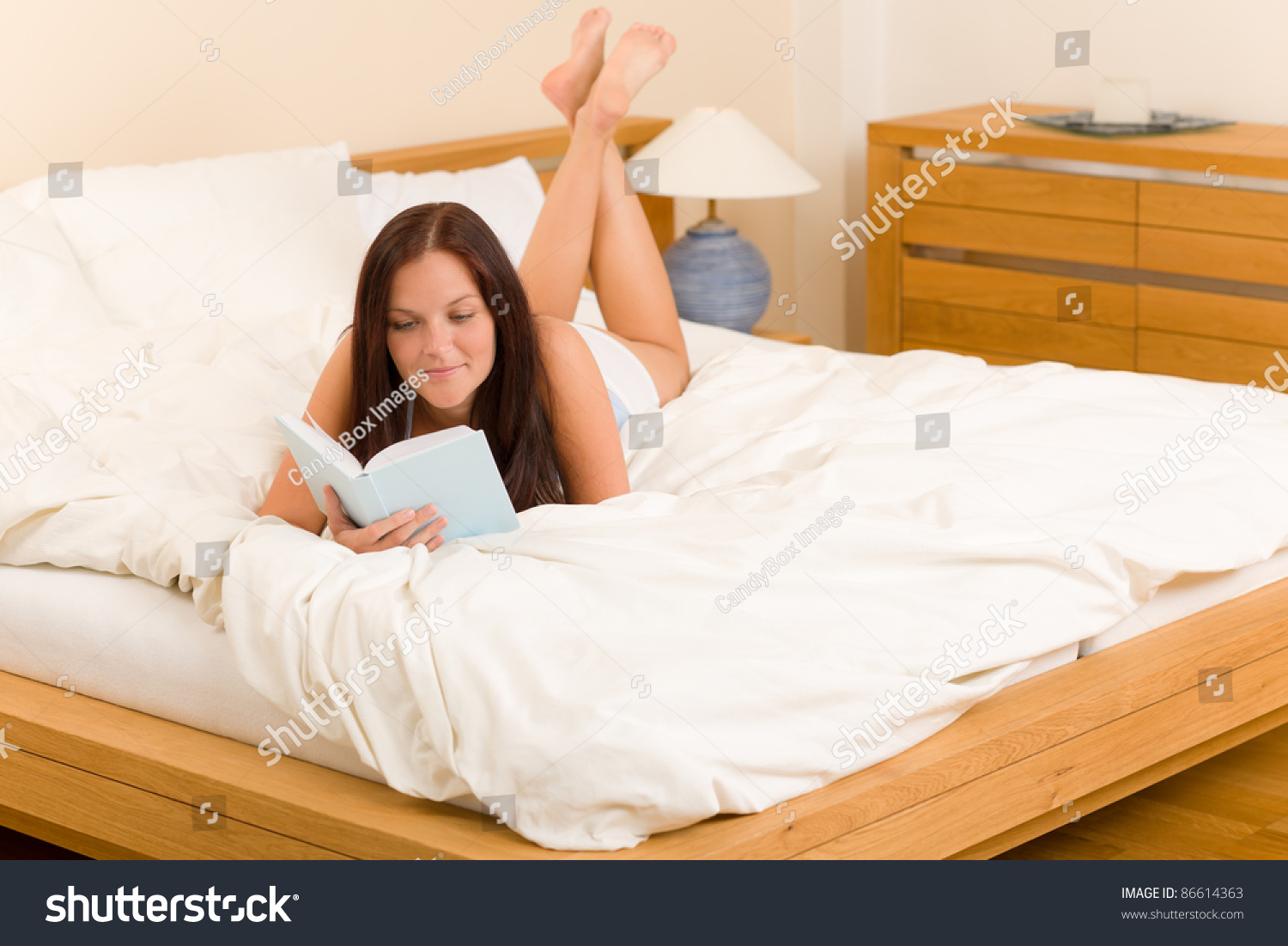Лежит на кровати читает