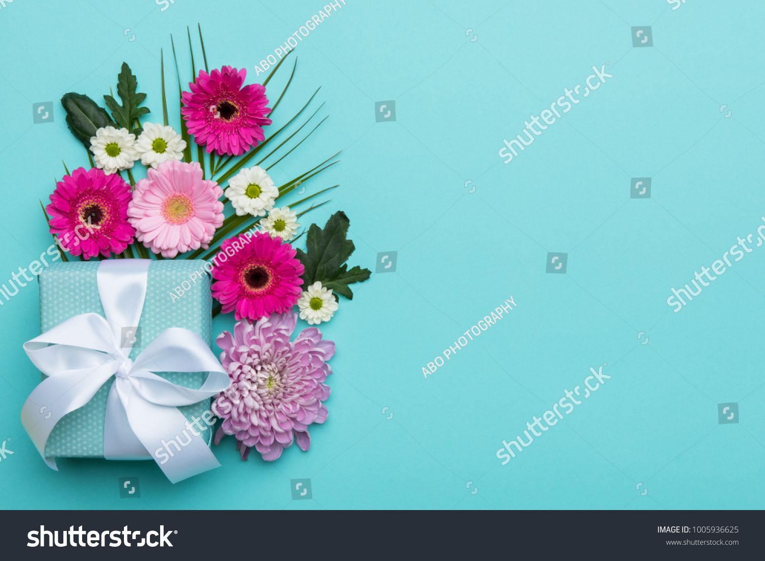 Happy Mother's Day, Women's Day, Valentine's Day or Birthday Pastel Candy Colors Background. Floral flat lay greeting card with beautifully wrapped present and copy space. #1005936625