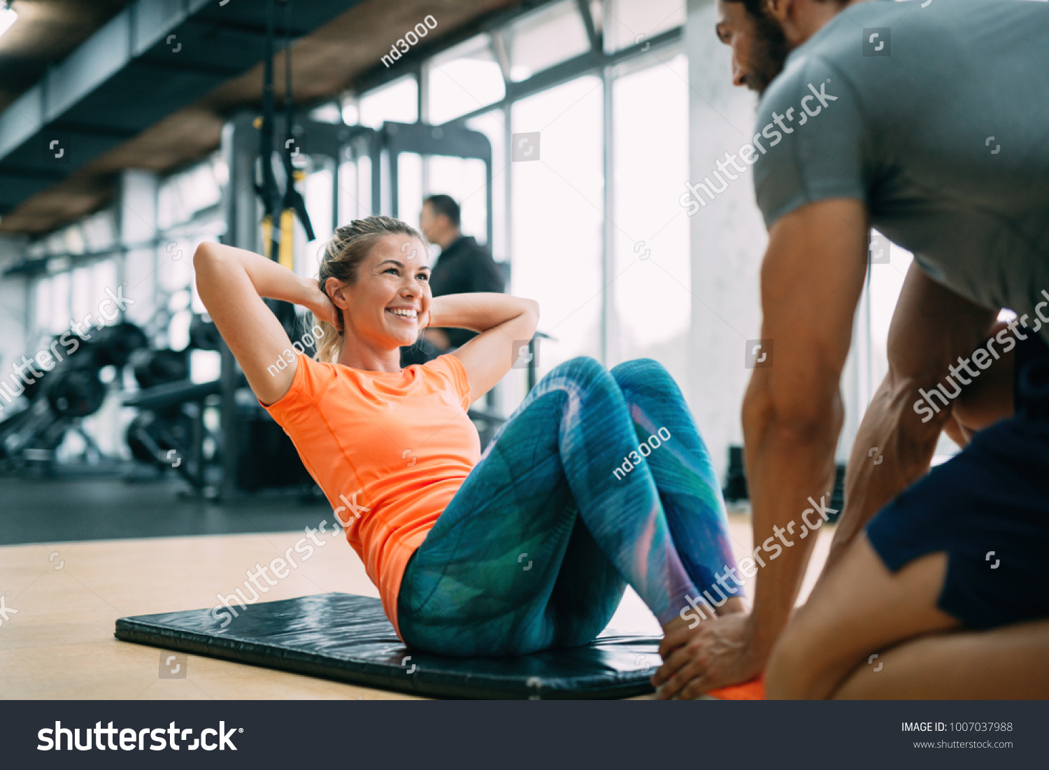 Personal trainer assisting woman lose weight #1007037988