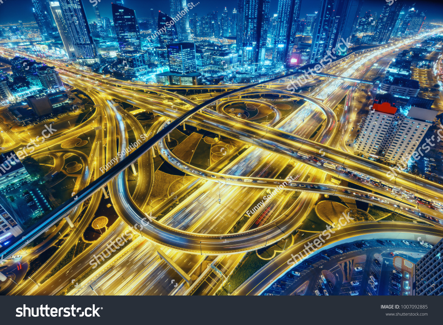 Aerial view of big highway interchange with traffic in Dubai, UAE, at night. Scenic cityscape. Colorful transportation, communications and driving background. #1007092885