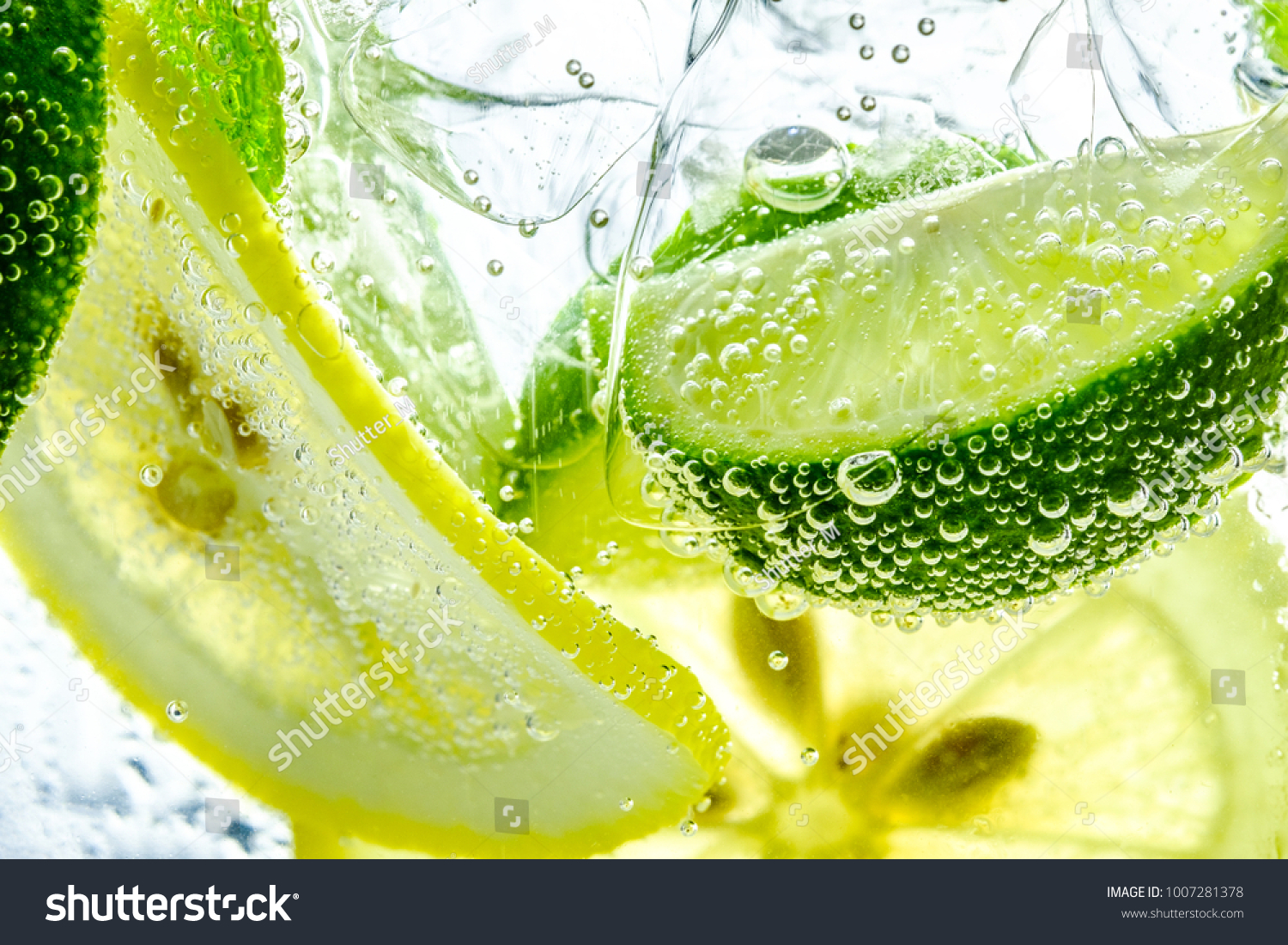 Lemon slice drop in fizzy sparkling water, juice refreshment #1007281378
