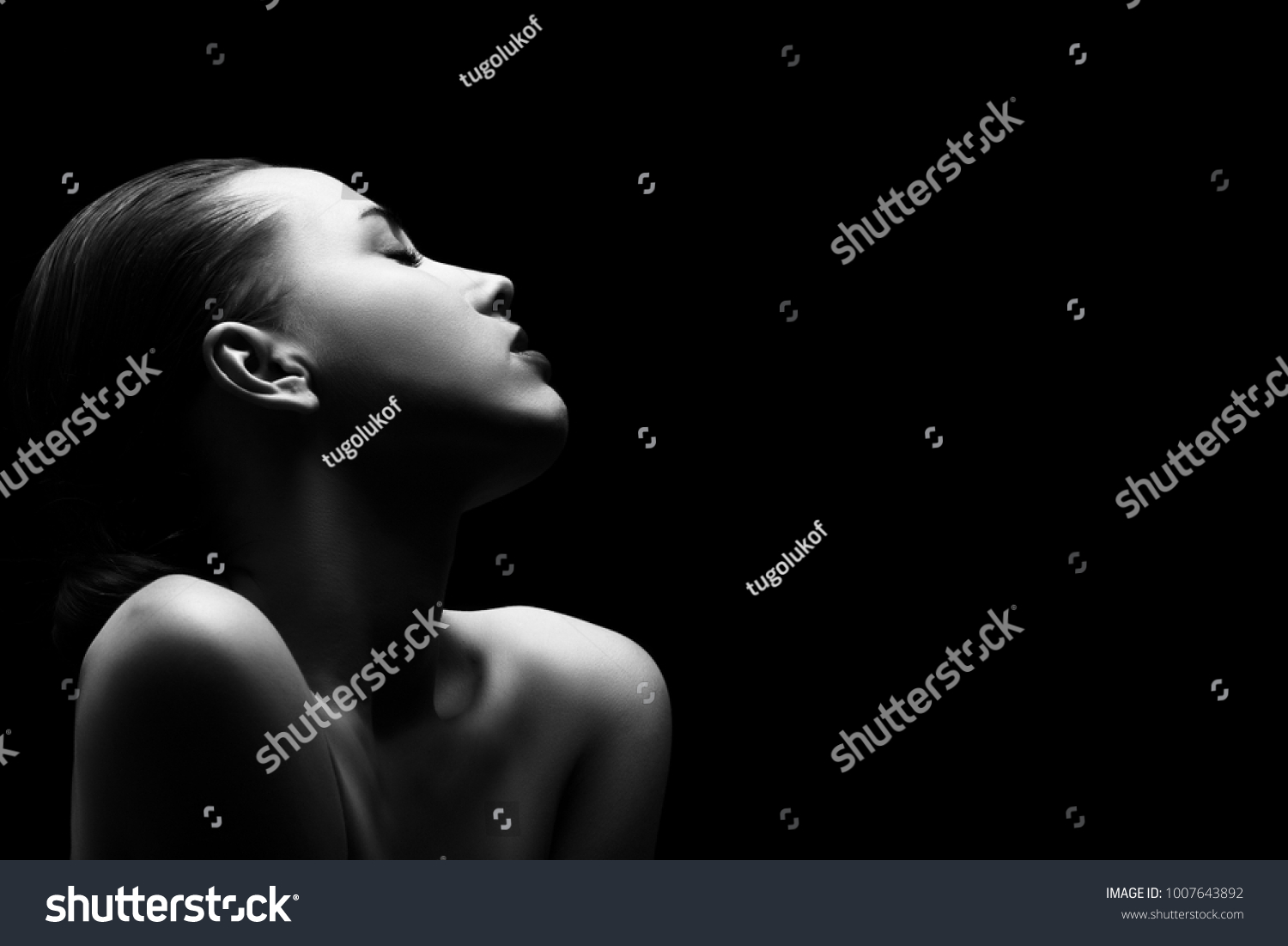 sensual aroused woman with closed eyes on black background #1007643892