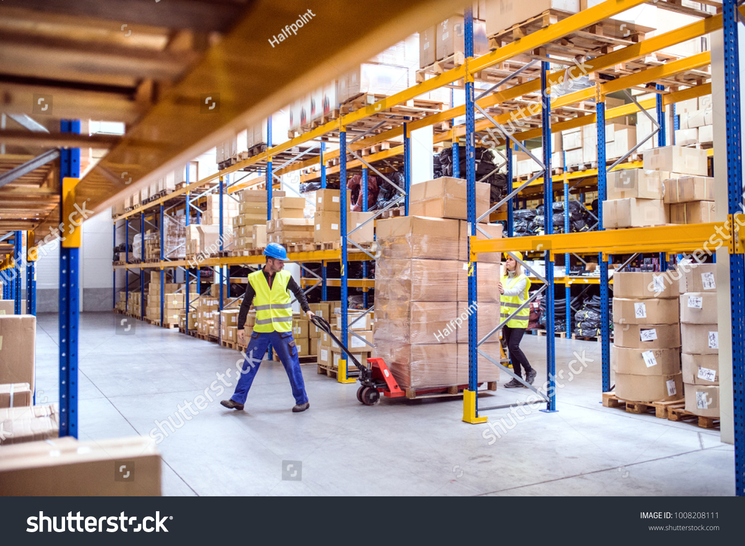 Warehouse workers pulling a pallet truck. #1008208111