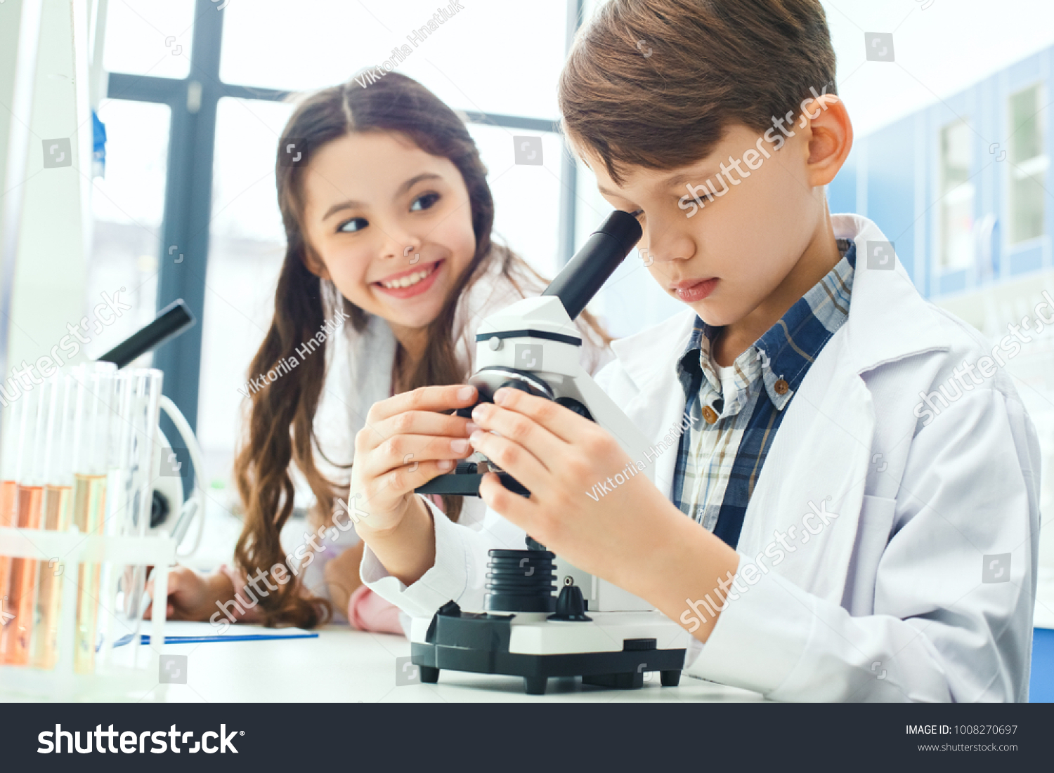 Little kids learning chemistry in school laboratory microscope experiment notes #1008270697