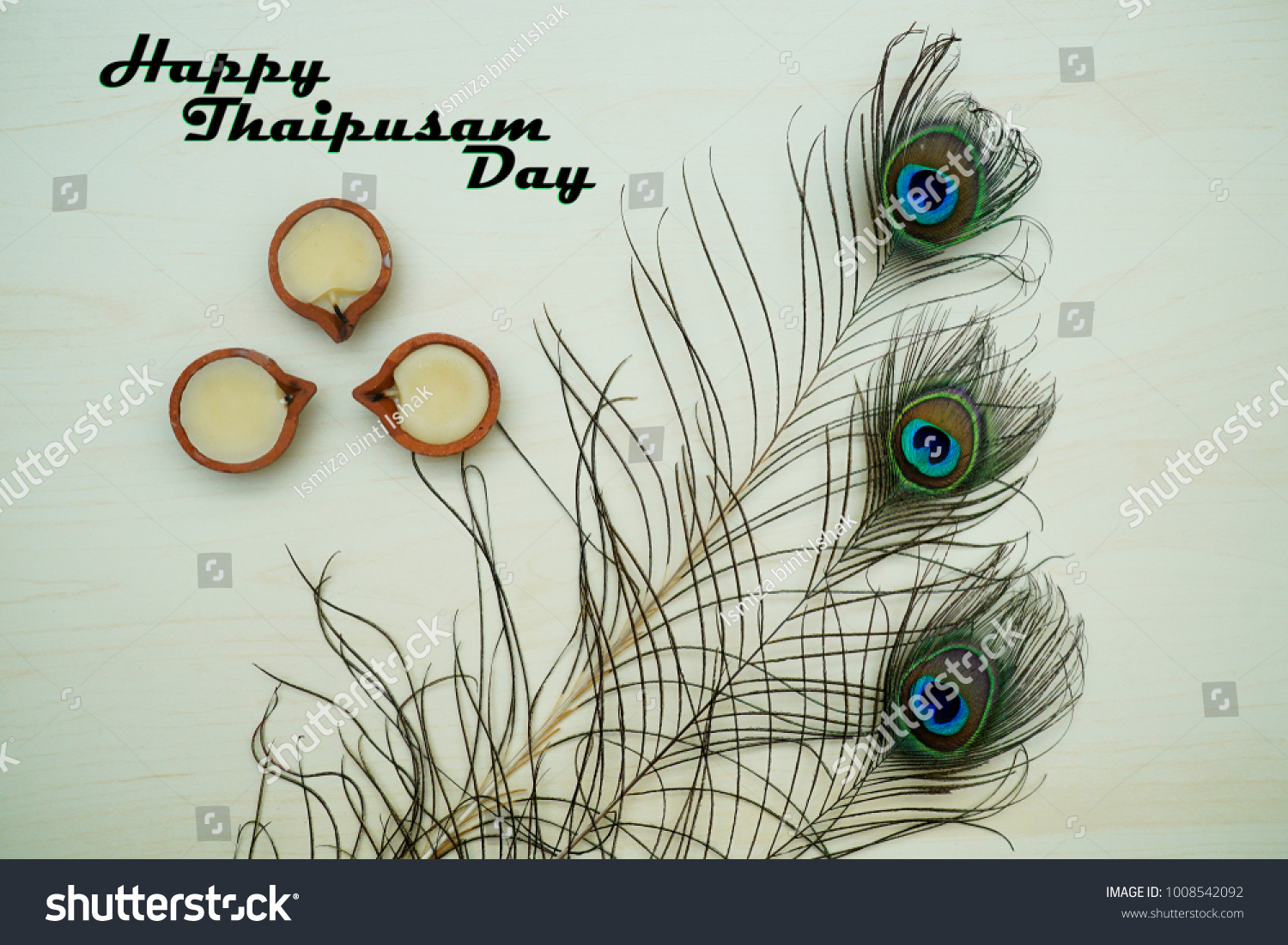 Top or flat lay view of a peacock feathers on a wooden background with a words HAPPY THAIPUSAM DAY. Celebrate by a hindu religions.  A religions conceptual. #1008542092