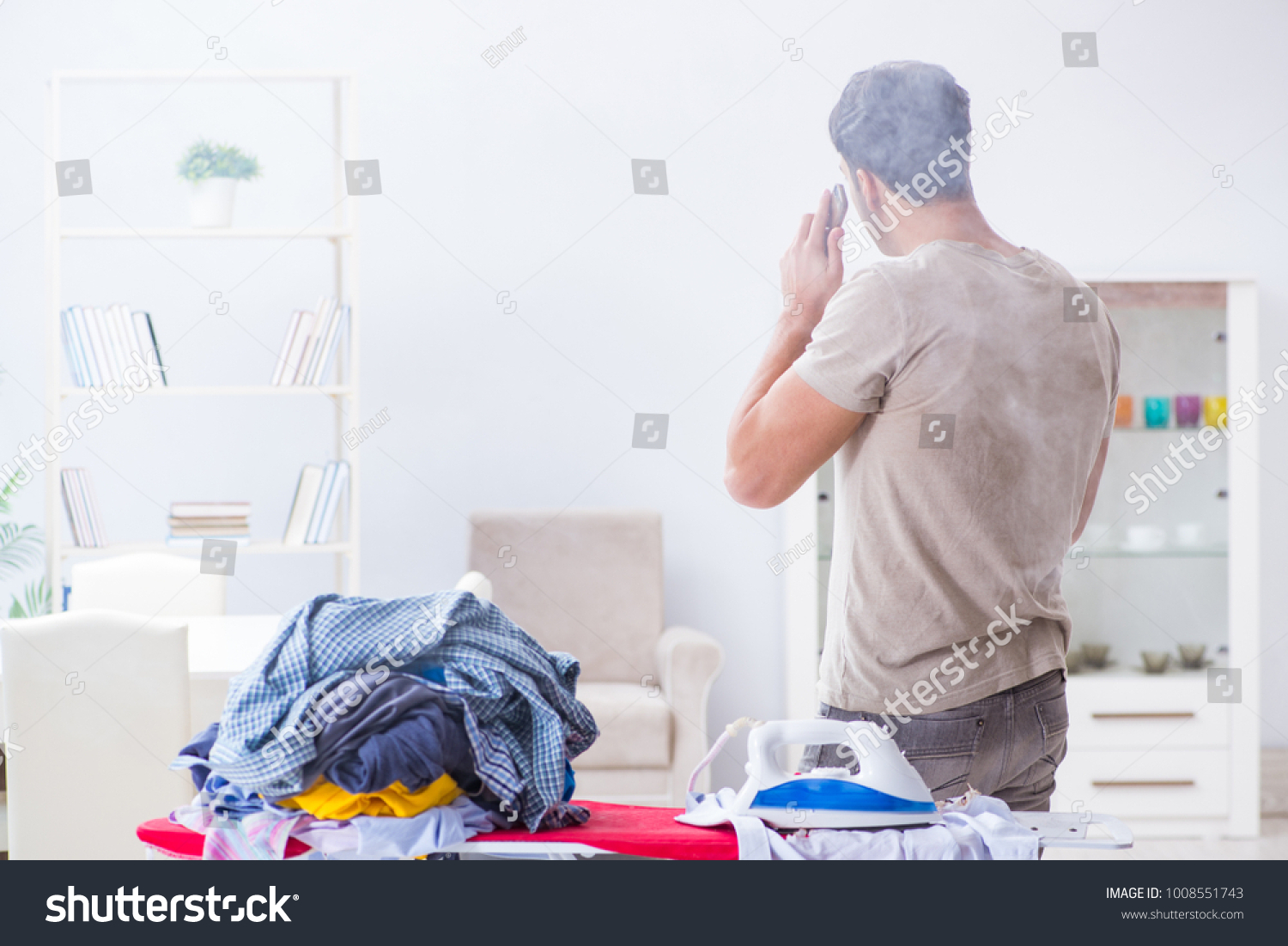 Inattentive husband burning clothing while ironing #1008551743