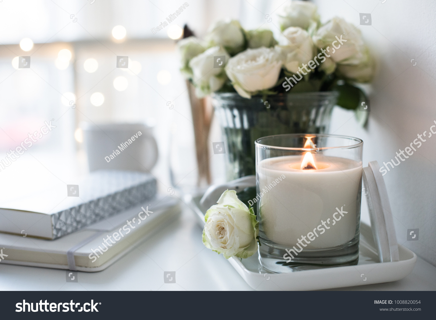 White room interior decor with burning hand-made candle and bouq #1008820054