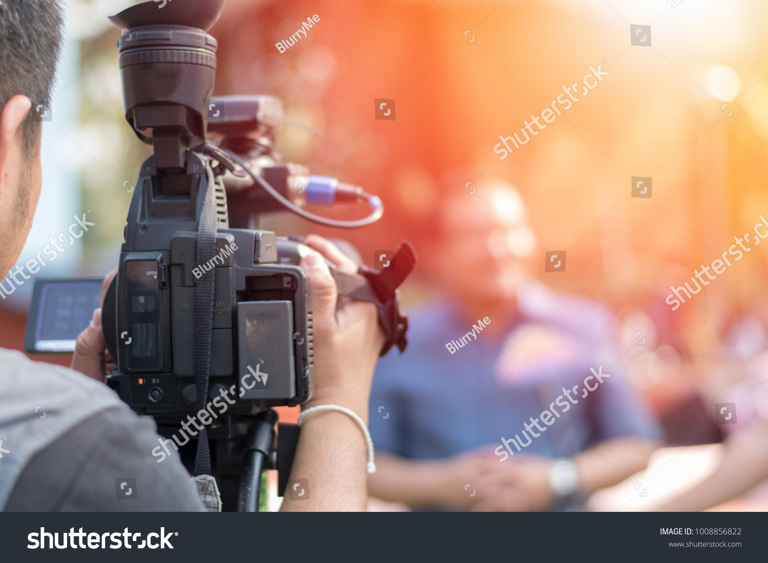 Behind the scene concept. Cameraman working on professional camera taking film interviewer interview celebrity people making news outdoors.  #1008856822
