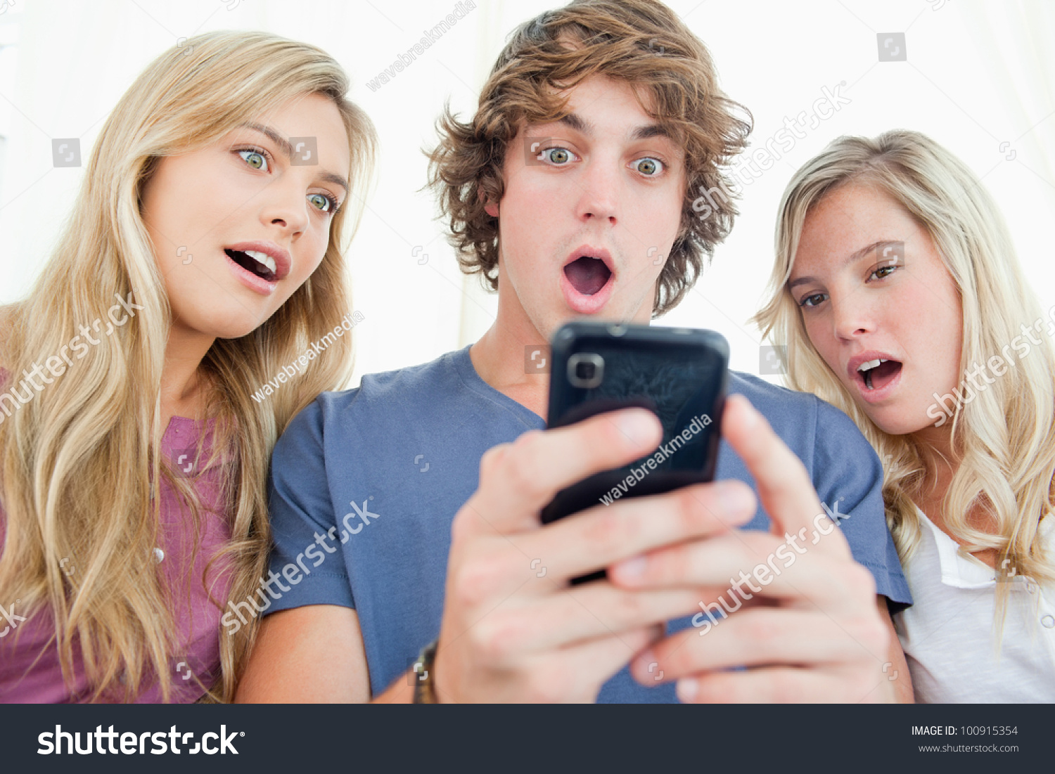 A group of friends look at the phone screen in shock #100915354